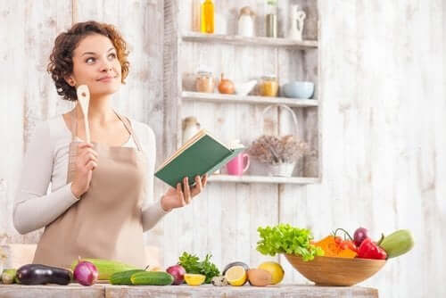 Kvinde med kogebog i hånden skal til at lave en salat