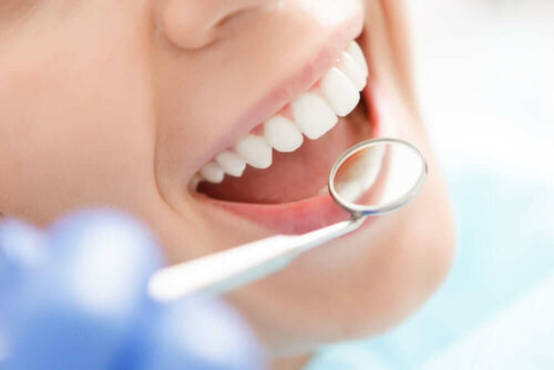Dentist checking teeth with mirror.