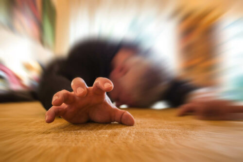 Man on the ground experiencing an epileptic seizure.