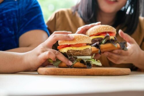 Two people about to eat cheeseburgers.