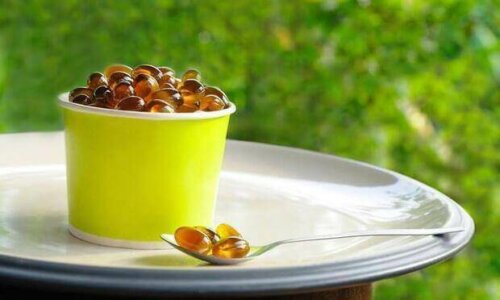 Lecithin supplement capsules in a container and on a spoon.