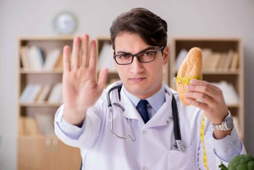 Nutritionist telling people to avoid gluten to avoid neurological diseases, holding a roll and holding other hand up to say "stop".