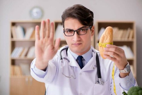 Nutritionist telling people to avoid gluten to avoid neurological diseases, holding a roll and holding other hand up to say "stop".