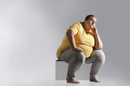 Obese woman sitting on a box with poor postural hygiene.