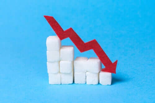 Sugar cubes stacked in a staircase with a red down arrow on them.