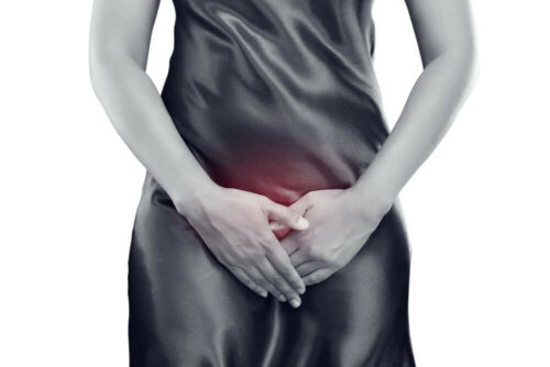 Black and white photo of woman with hands over crotch.