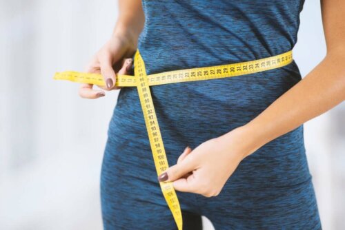 A woman measuring her waist.