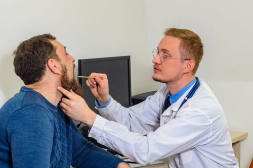 A man getting his vocal cords checked by a doctor.