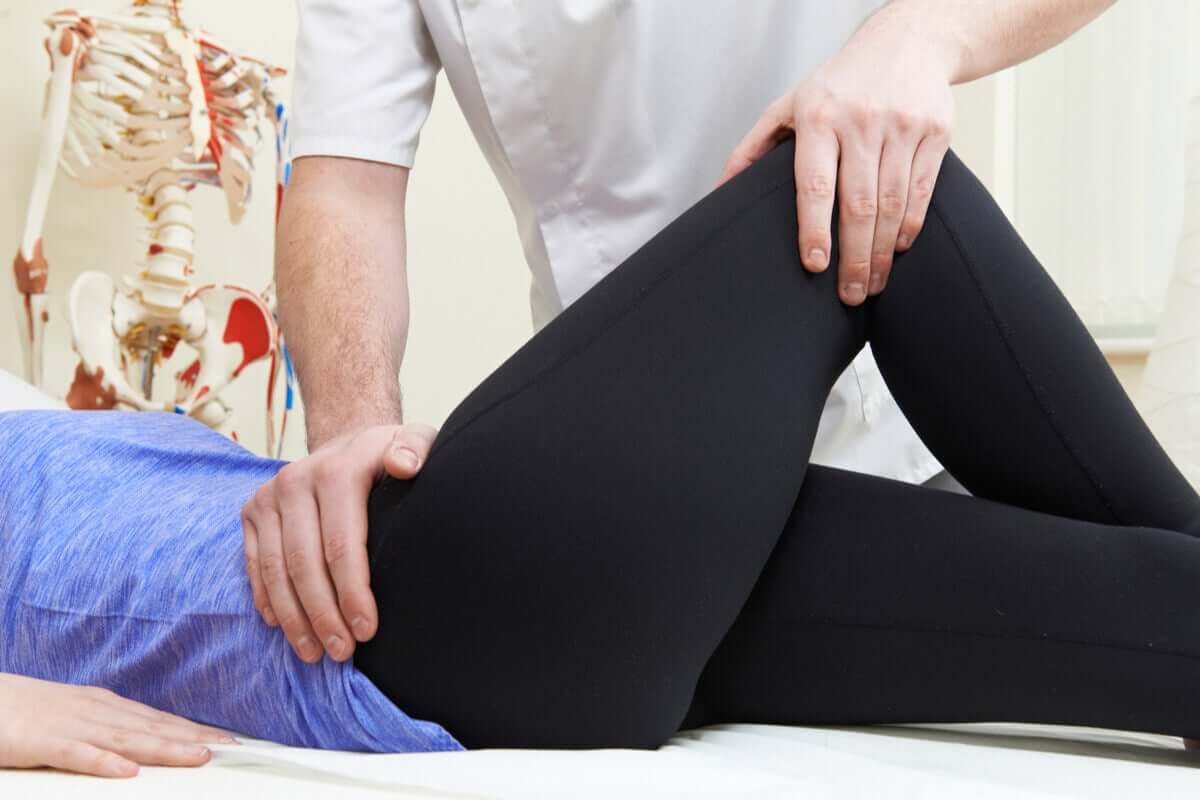 A physical therapist performing hip exercises on a patient.