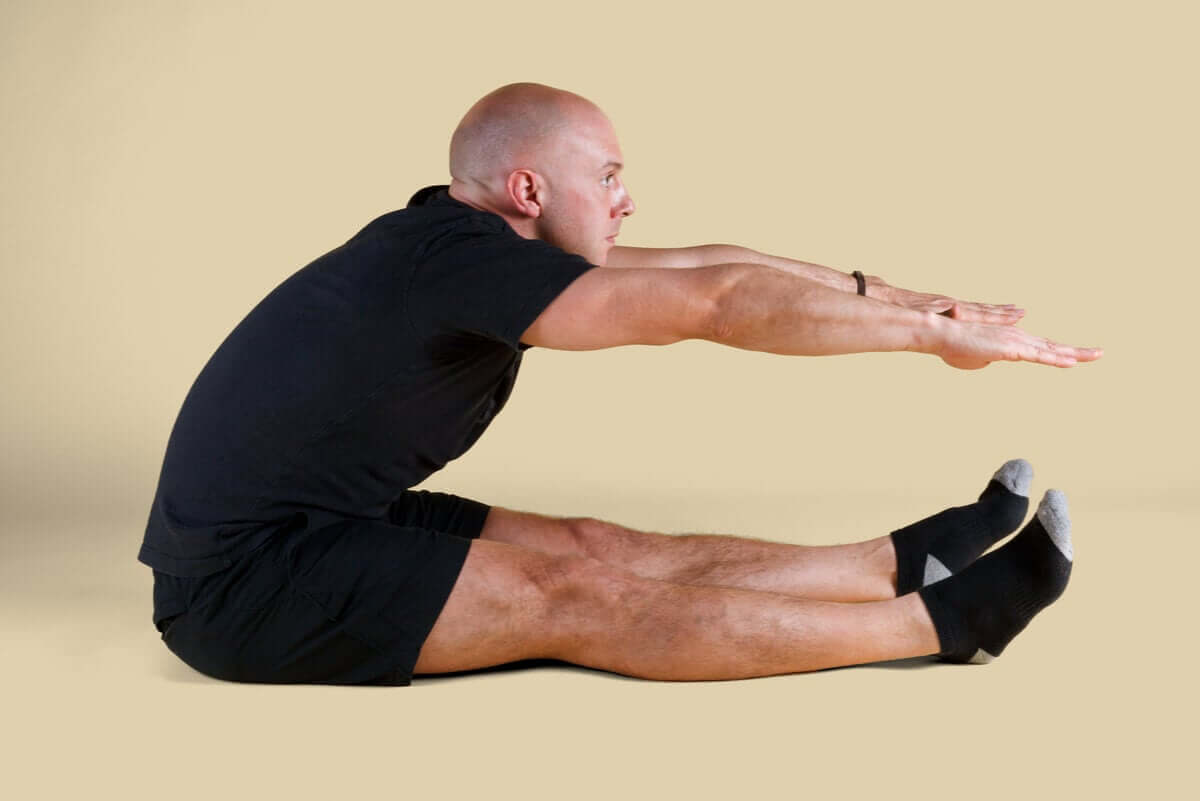 A man doing a Pilates roll up.