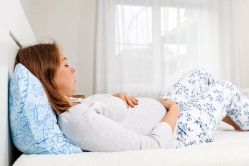 Epilepsie und Schwangerschaft - schwangere Frau liegt im Bett