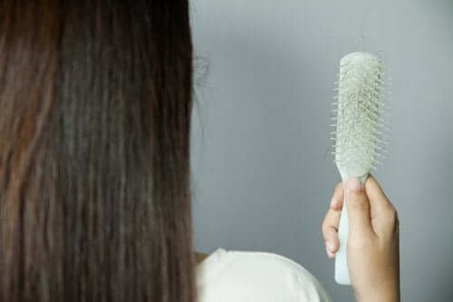 Kvinde ser på hår på sin hårbørste