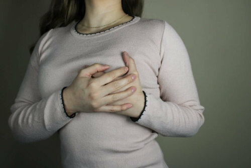 A woman holding her breast.