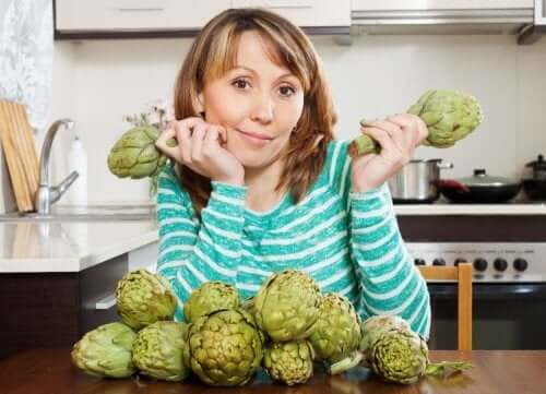 A woman holding artichokes.