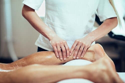 A physical therapist massaging the calf.