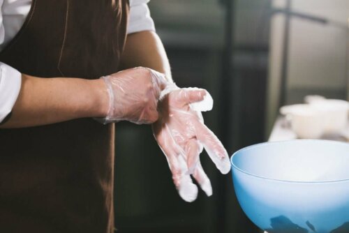 A person wearing gloves to cook food.