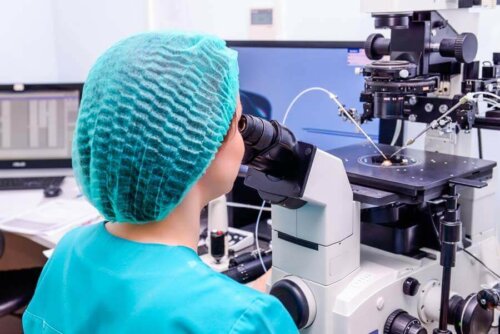 A woman looking through a microscope.