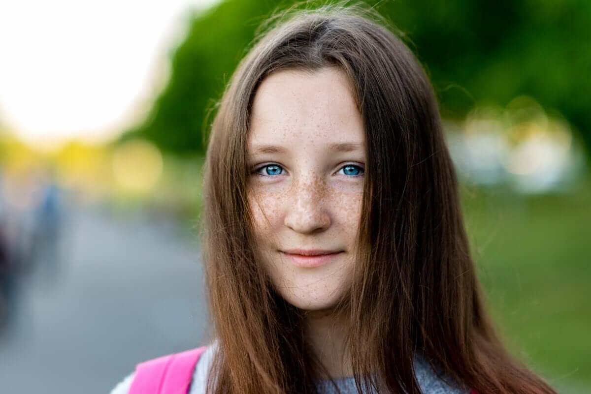 A teenage girl with freckles and blue eyes.