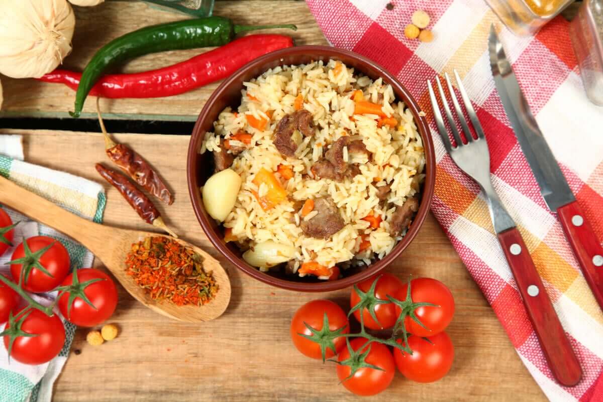 A bowl of bulgur wheat, tomatoes, and peppers.