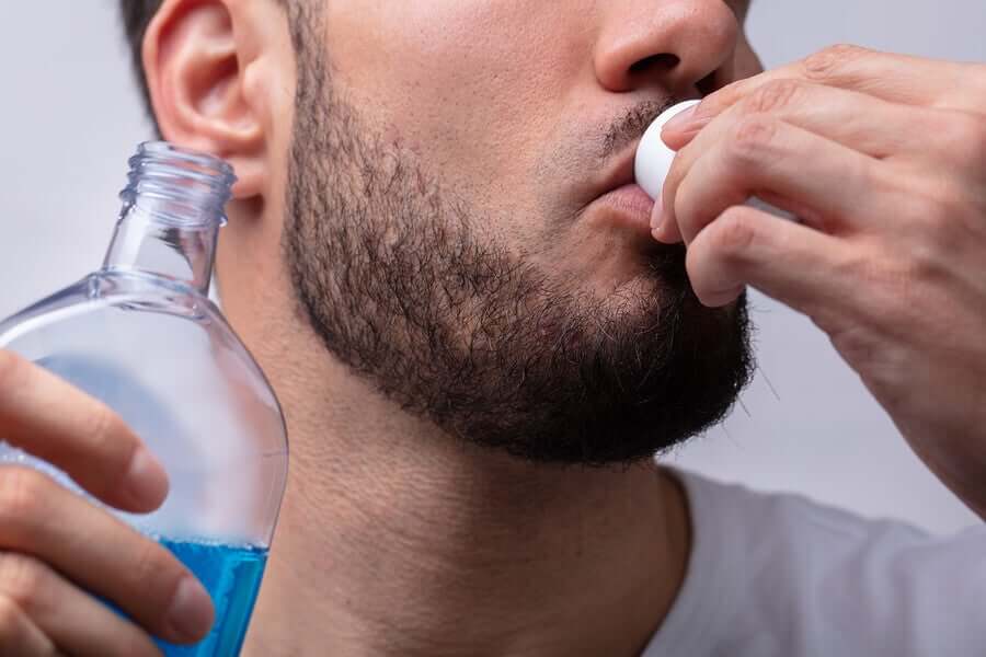 Mężczyzna używający płynu do płukania ust.