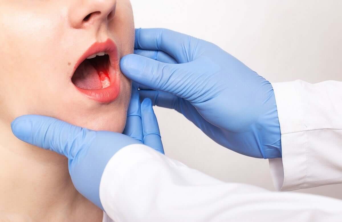 A dentist looking at a woman's teeth.