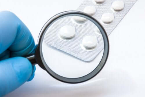 A magnifying glass revealing the expiration date on a blister pack of medication.