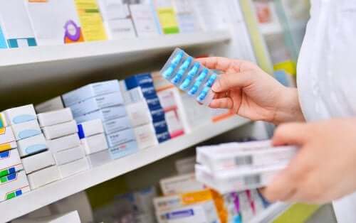 A pharmacist sorting medication on a shelf.