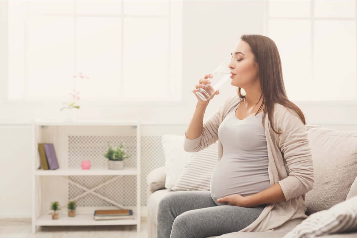 Pregnant woman drinking water.