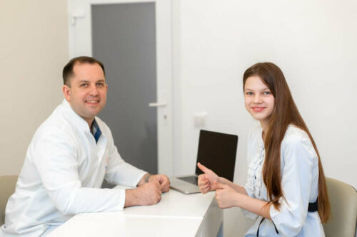 A doctor and a teenager posing for a picture.