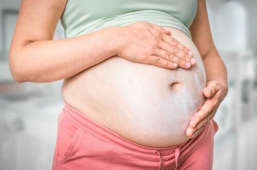A woman applying cream on her belly.