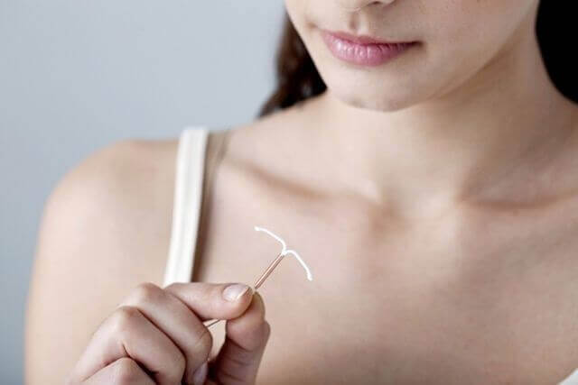 A woman holding a copper IUD.