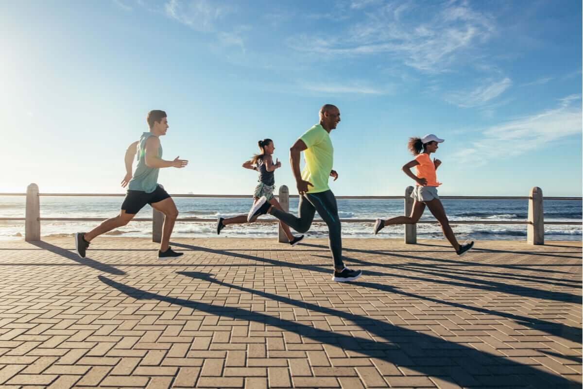 A group of runners running along the beach.