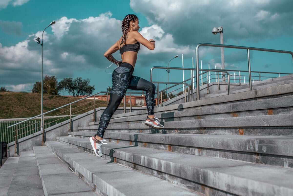 A woman running up an outdoor staircase.