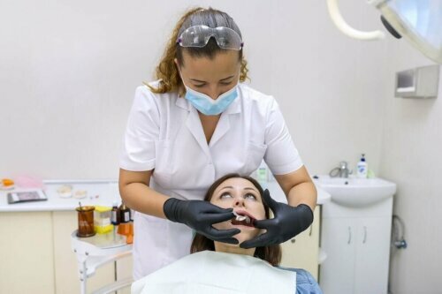 جسر الأسنان: أنواعه وفوائده وعيوبه ؛ طبيب أسنان يقوم بفحص أسنان المريض