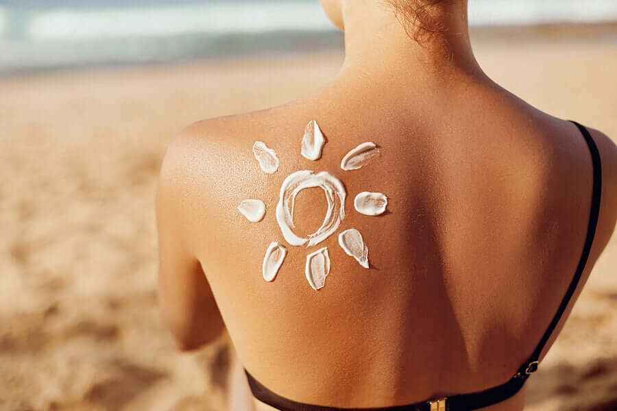 Mythen über Sonnencreme - Frau mit einer Blume aus Sonnencreme auf der Haut.