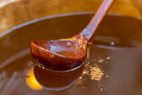 A wooden ladle inside a bowl of honey.
