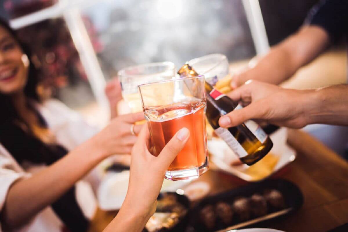 Friends toasting with alcohol in a bar.