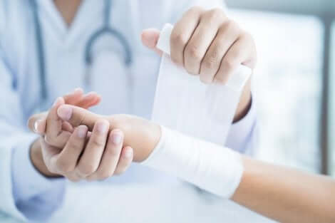 A nurse is bandaging a wrist.