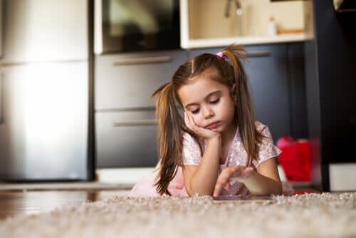 A child lying on the floor looking thoughtful.