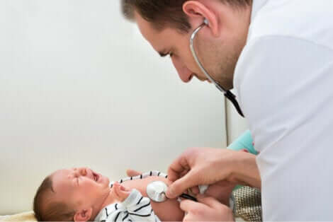 En baby græder, mens en læge tjekker den