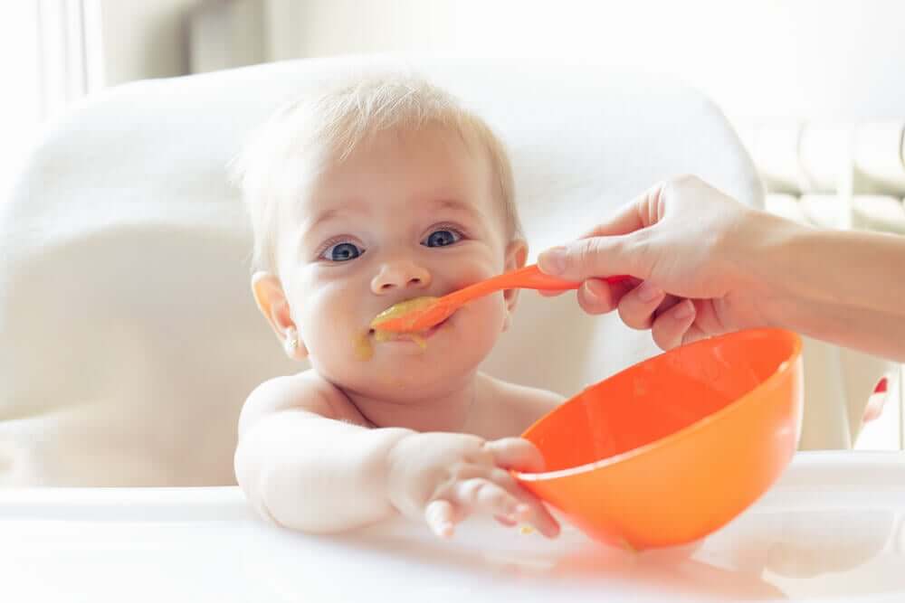 A baby having complementary feeding.