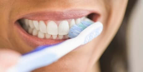 A woman brushing her teeth.