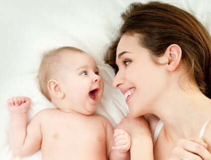 A mother is smiling at her baby.