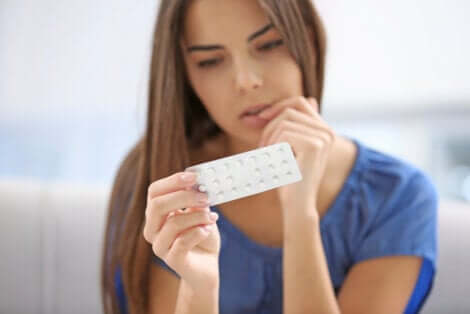 A woman is looking at pills.