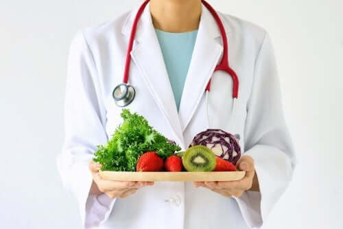 A nutritionist holding fruits and vegetables.