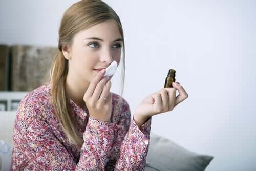 A girl smelling an oil.