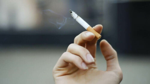 A hand holding a cigarette.