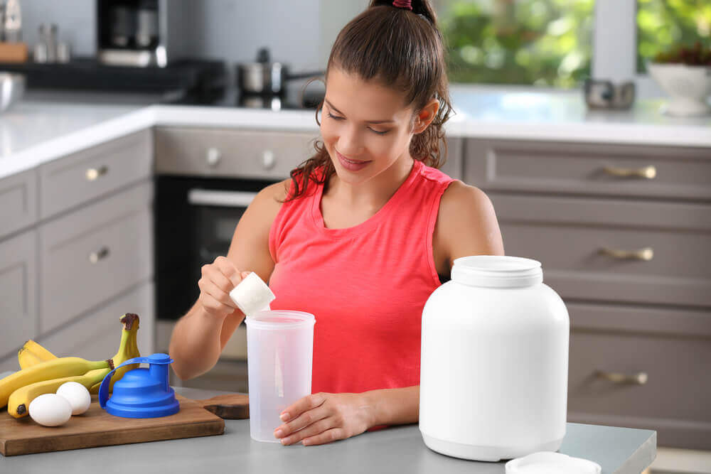 A woman making a protein shake.
