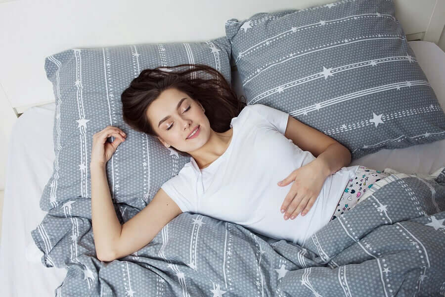 A woman resting comfortably in her bed.