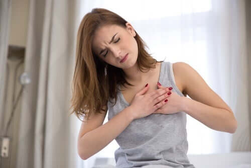 Angstbedingte Brustschmerzen: Frau mit schmerzverzerrtem Gesicht